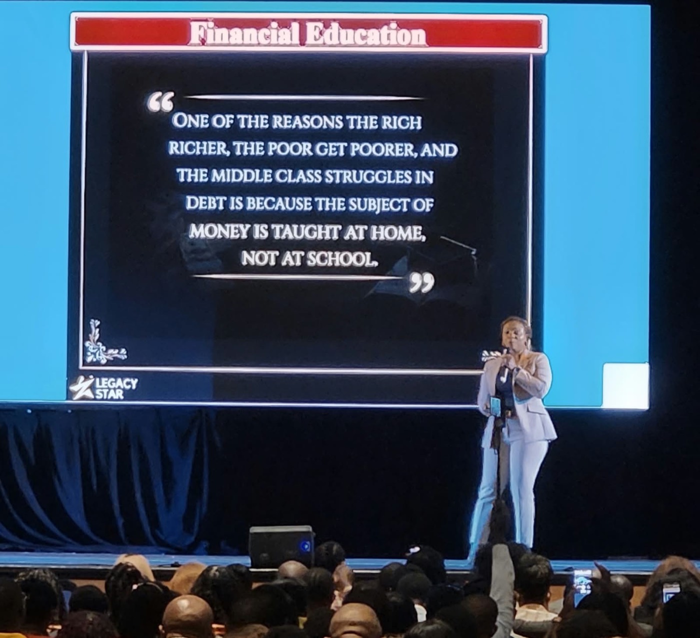 Stephania Fombo teaching a financial education session to a full room